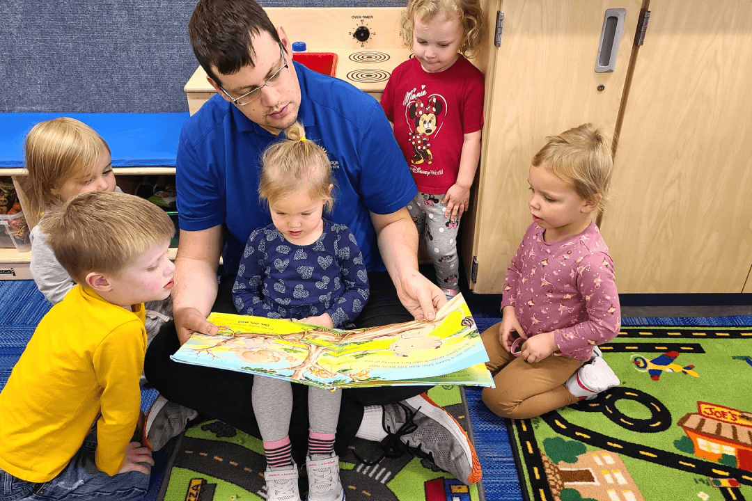 Teacher reading a book to class of children
