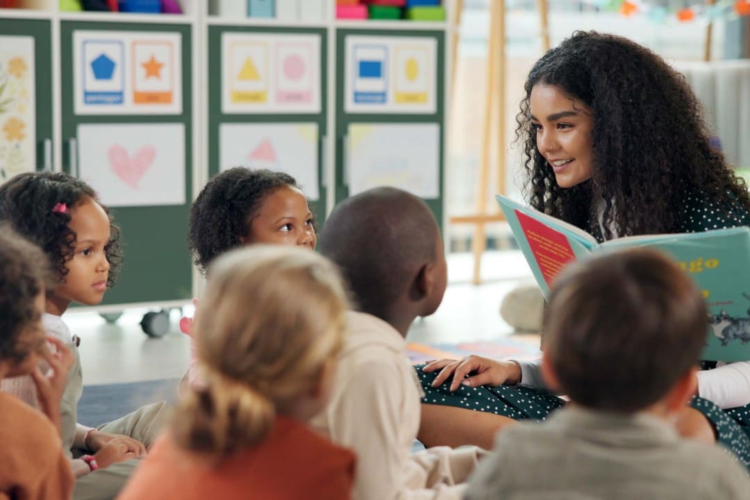 Female daycare staff member reading books to kids