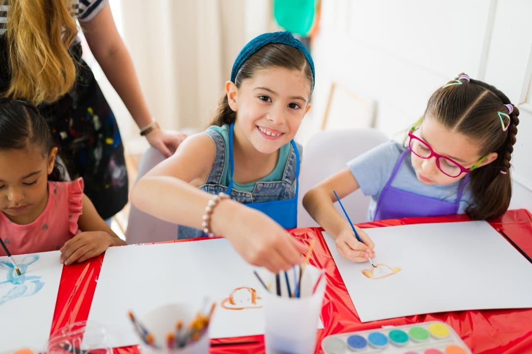 Girl painting in child care to build confidence for kindergarten
