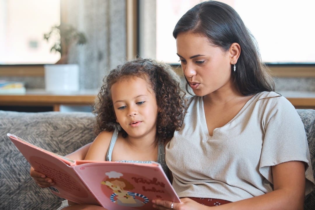 Mother reading her daughter a book during structured routine