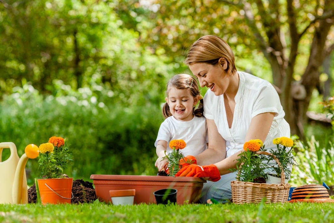 Mother teaching her child how to tend a garden