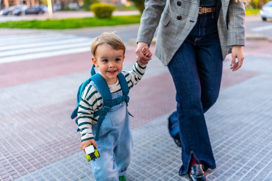 Male child walking into child care with parent