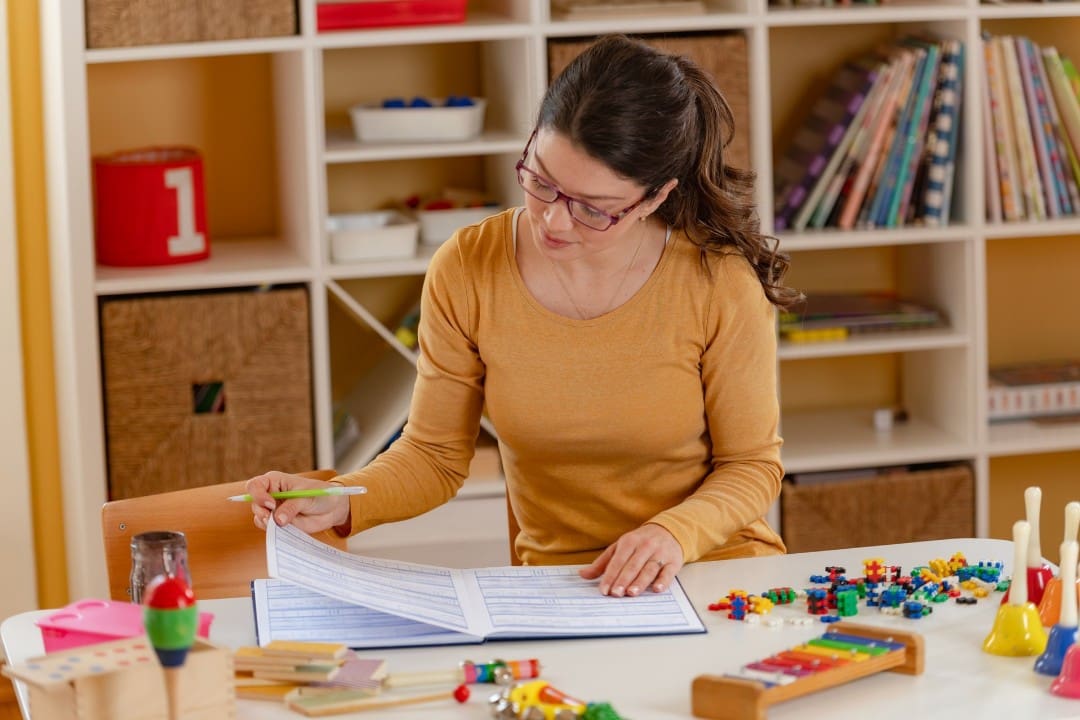 Preschool teacher reviewing lesson plan in childcare