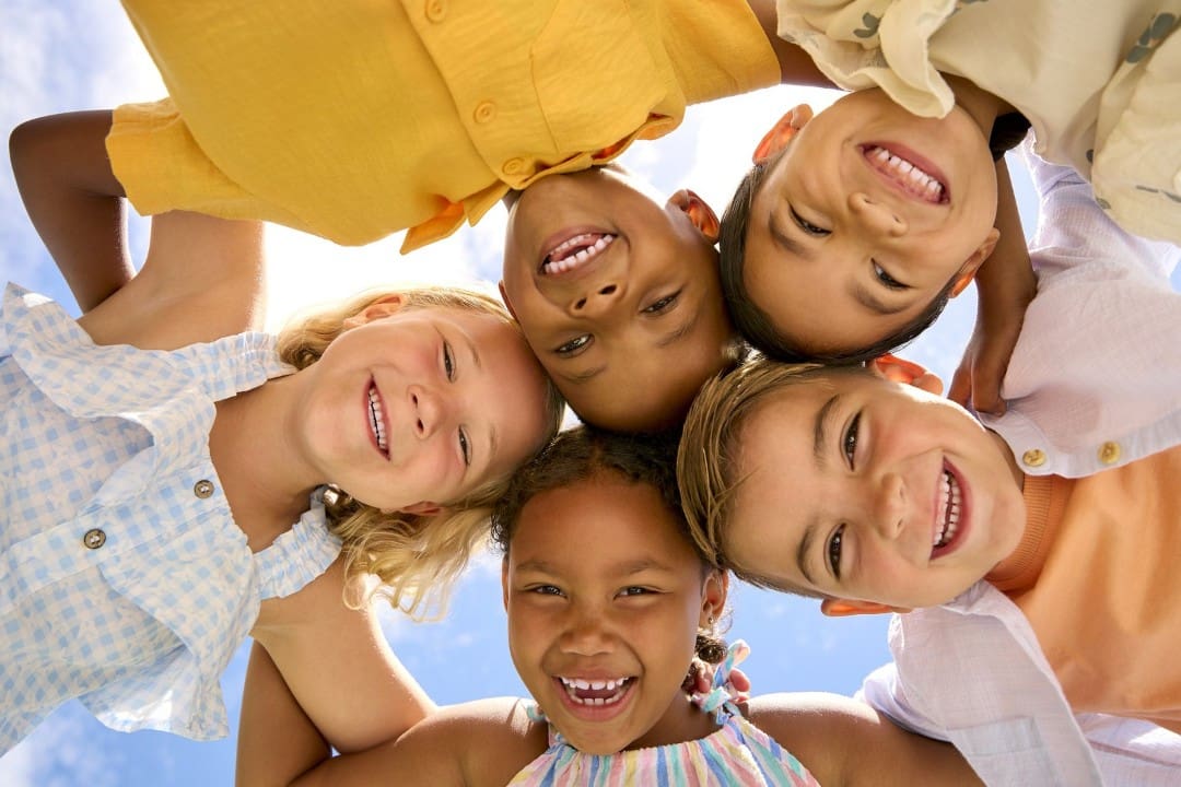 Smiling kids huddled together in a circle